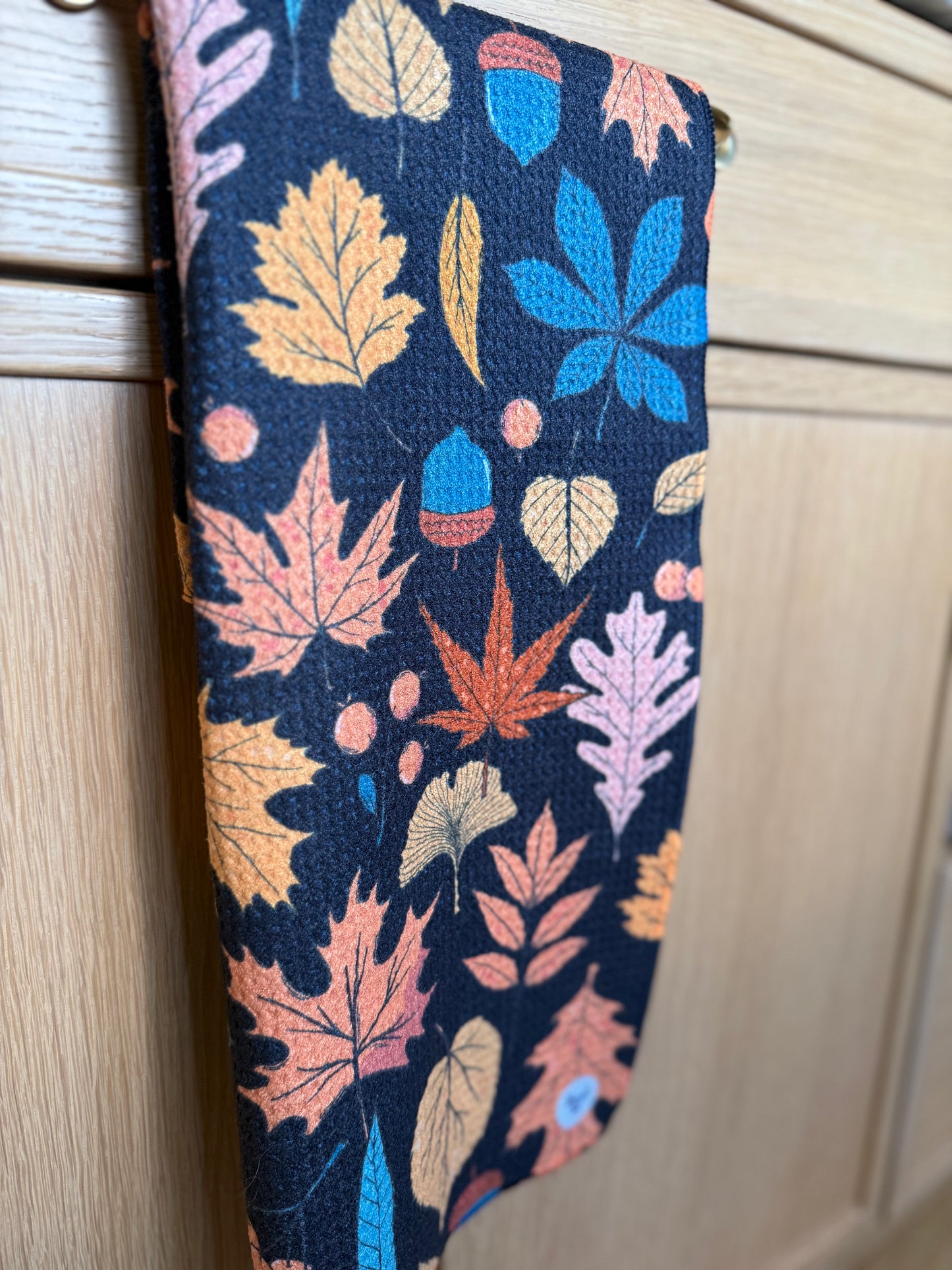 Fabric with colorful leaf pattern on a wooden surface