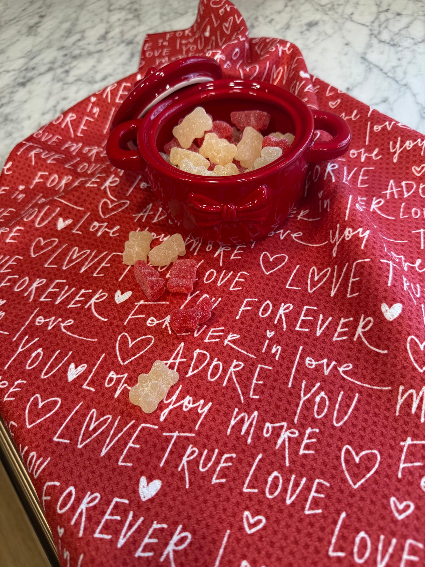Red CANDY bowl with treats on a red TOWEL with 'I love you' text