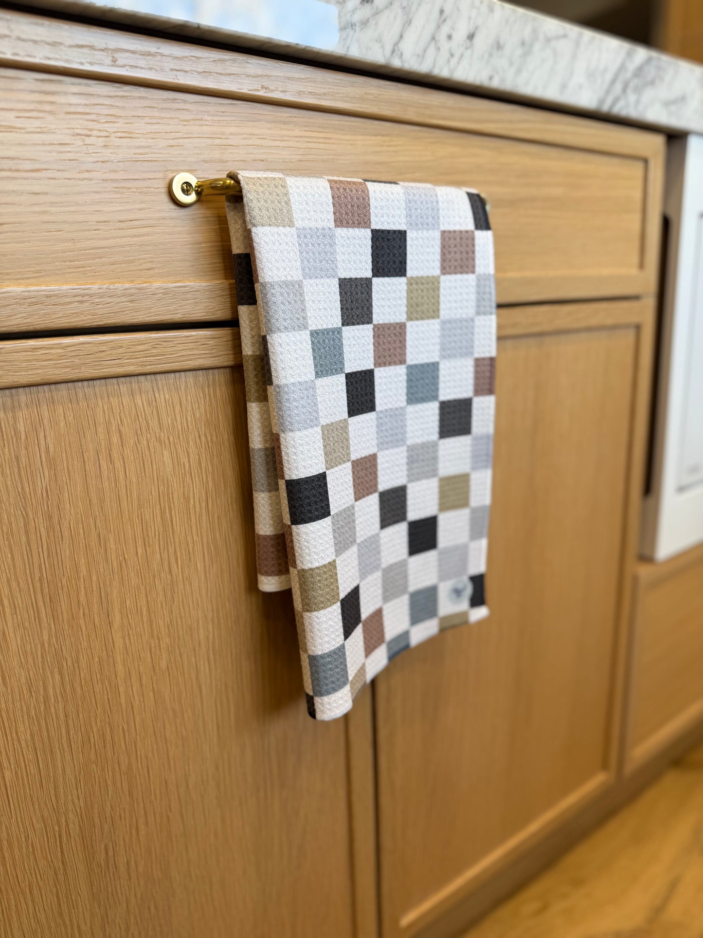 Checkered towel hanging on a wooden cabinet handle