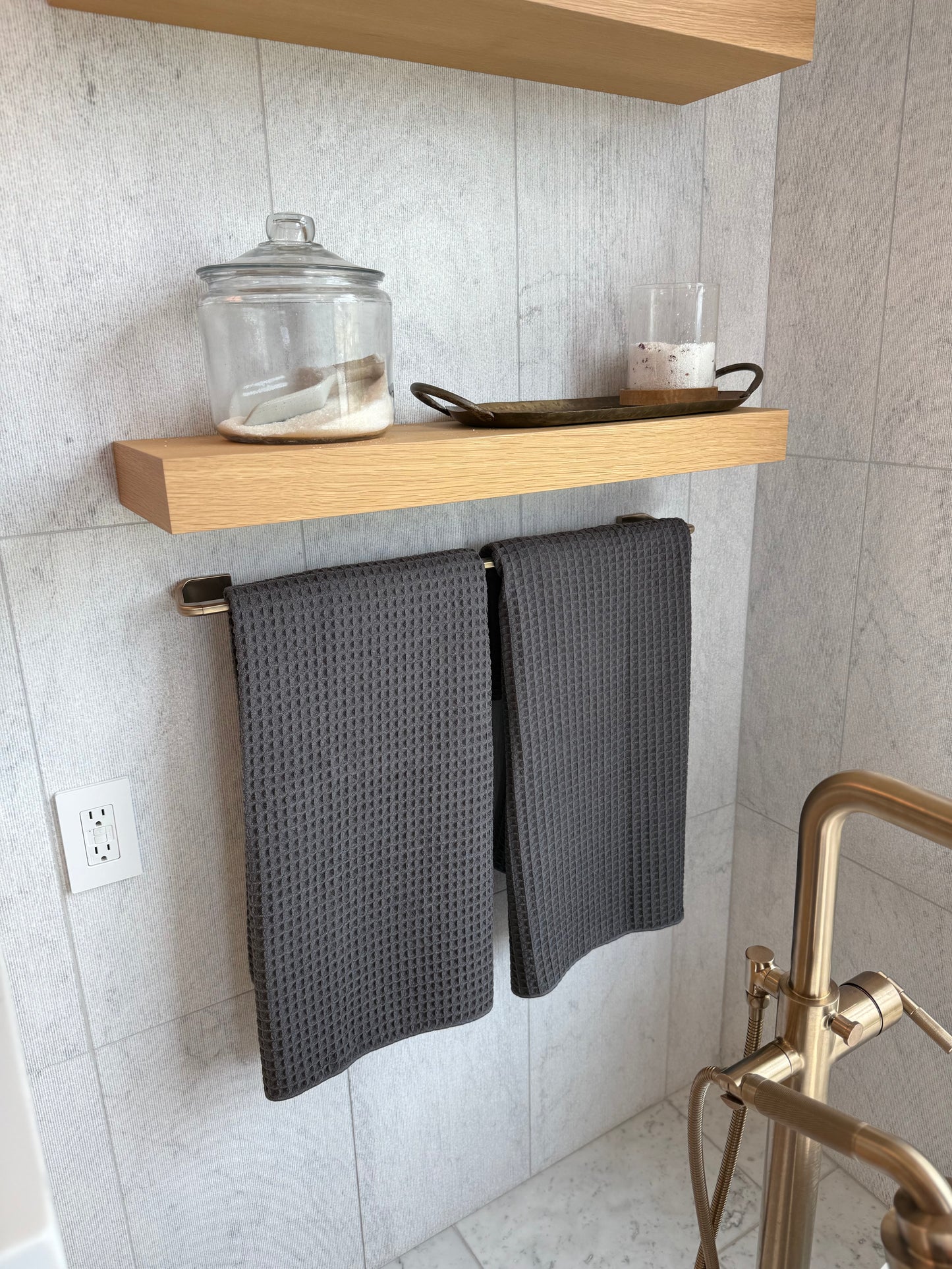 Towel rack with gray towels in a bathroom setting