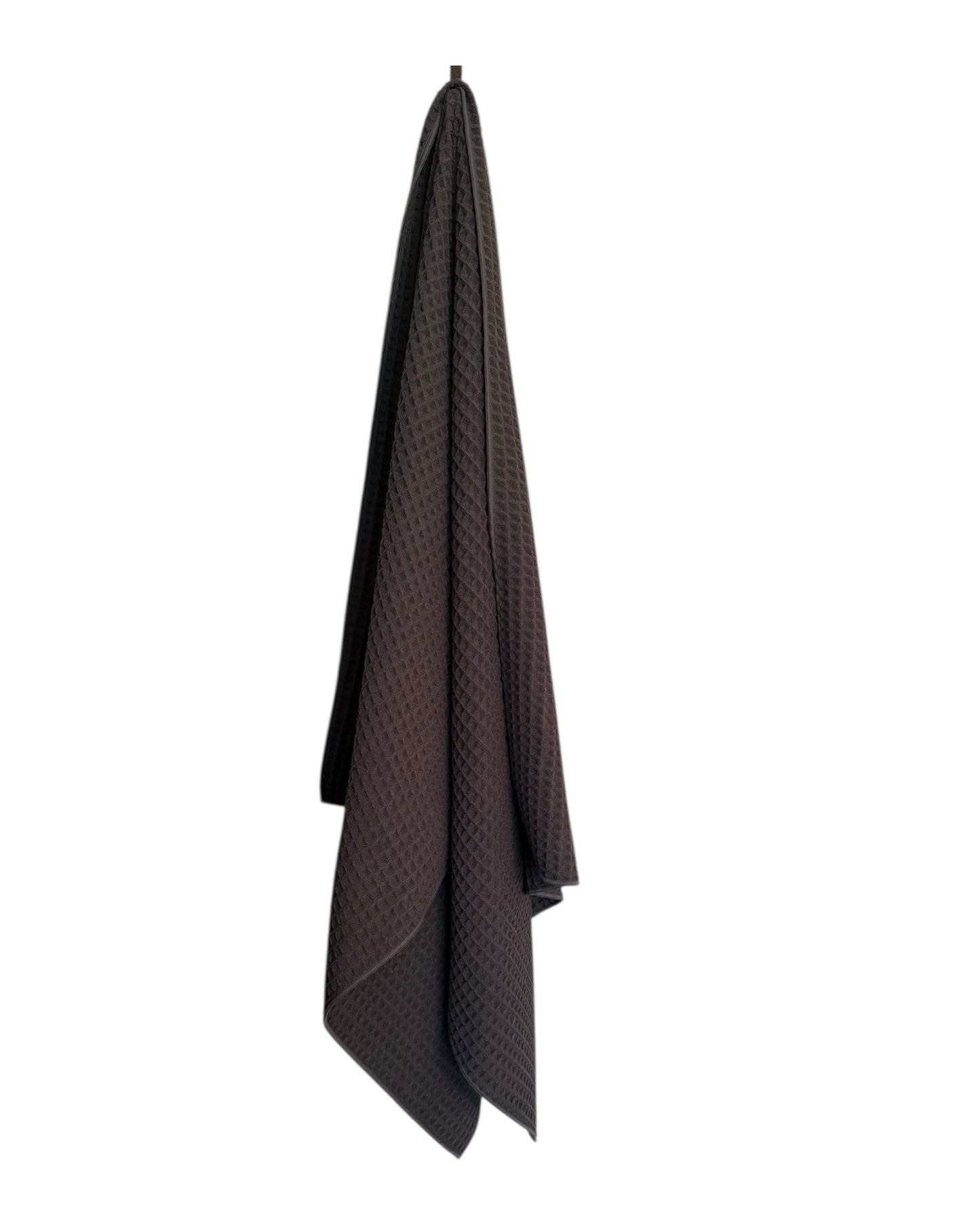 dark gray textured towel hanging on a white background