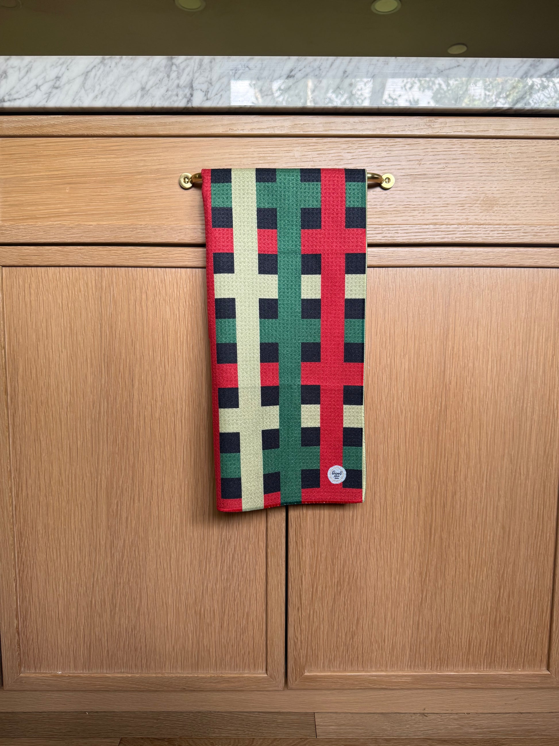 Colorful checkered towel hanging on a wooden surface red green and black