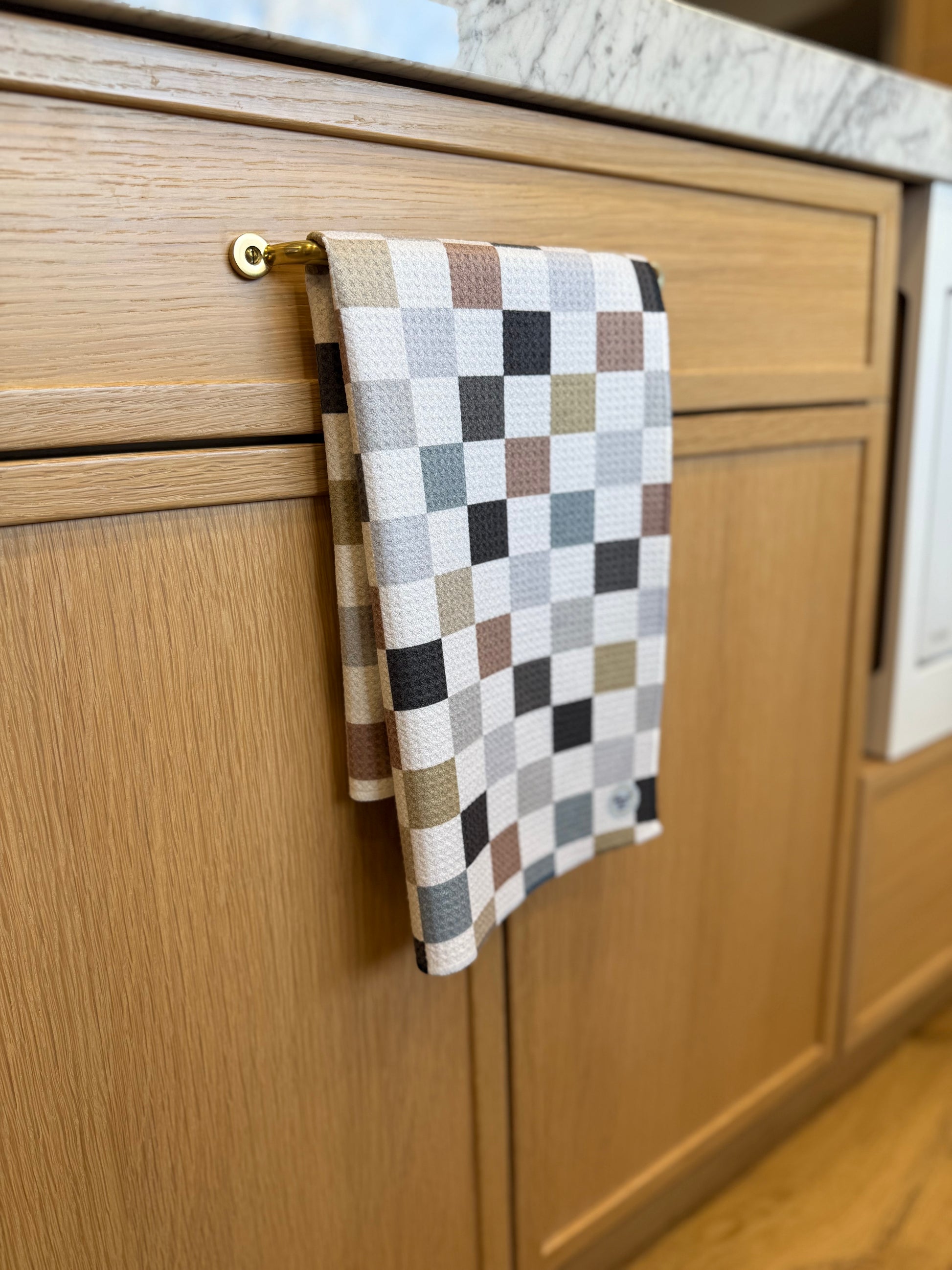 Checkered towel hanging on a wooden cabinet handle