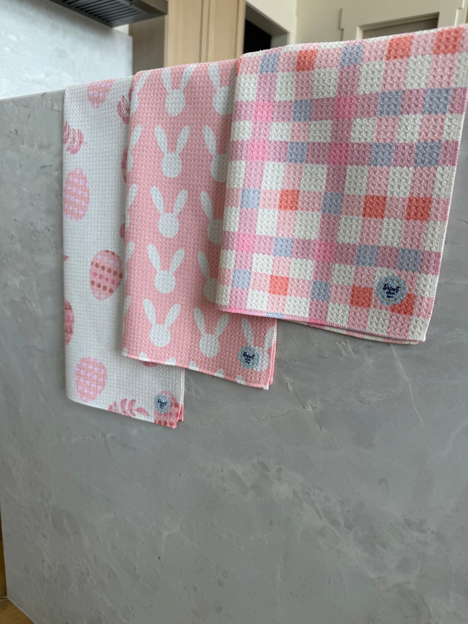 Set of pink and white patterned cloths on a gray surface
