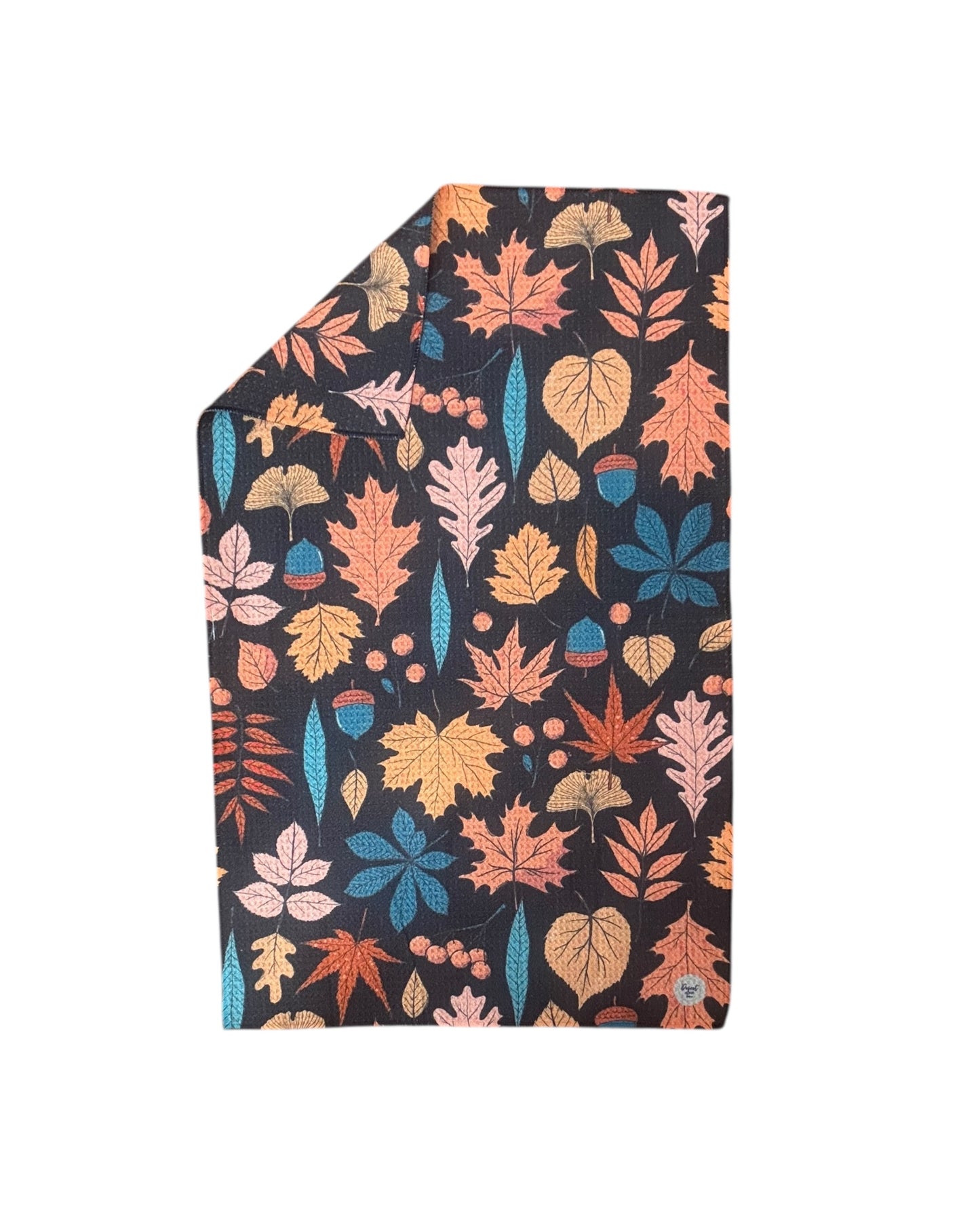 black dish towel with autumn leaf pattern on a white background