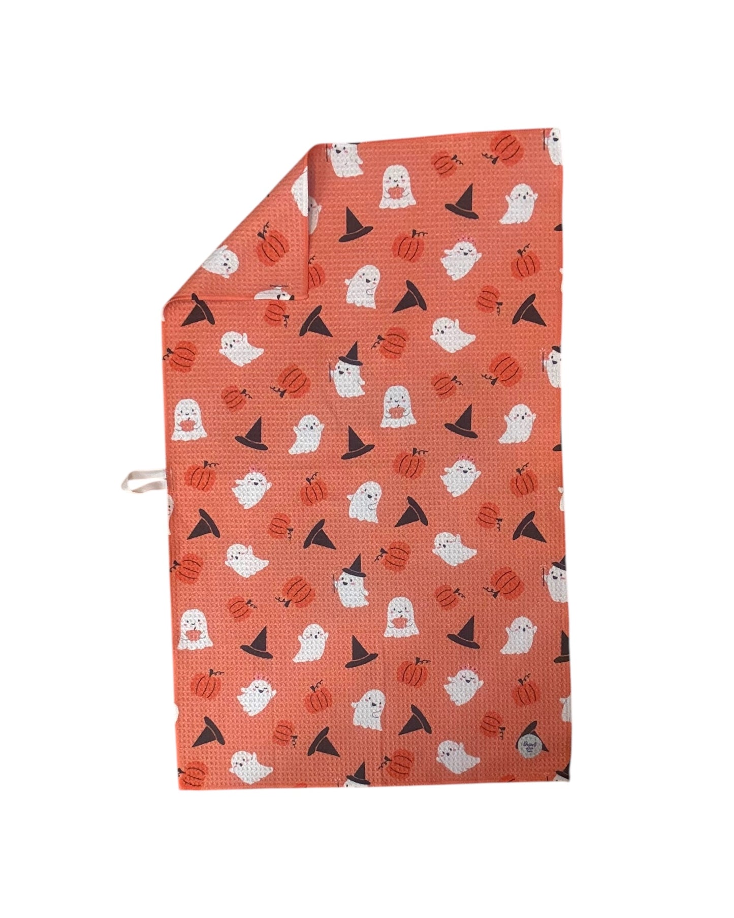Halloween-themed patterned towel with ghosts, pumpkins, and witches' hats on orange  background.